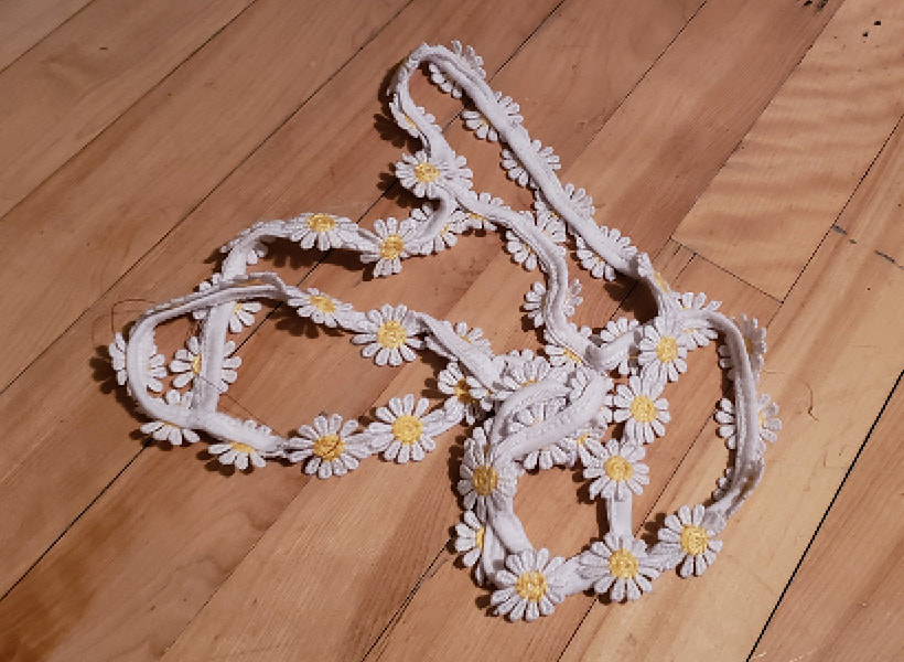 A string of daisy appliqués, white petals and yellow centres.